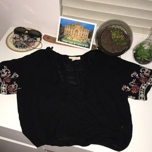 Black loose crop with floral print on the sleeves.